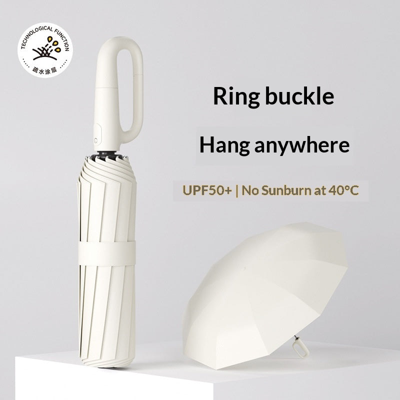 Closed folding umbrella beside an open umbrella canopy with ring handle