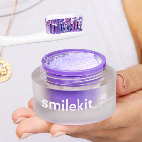 Open purple Smilekit powder jar with powder-coated toothbrush above