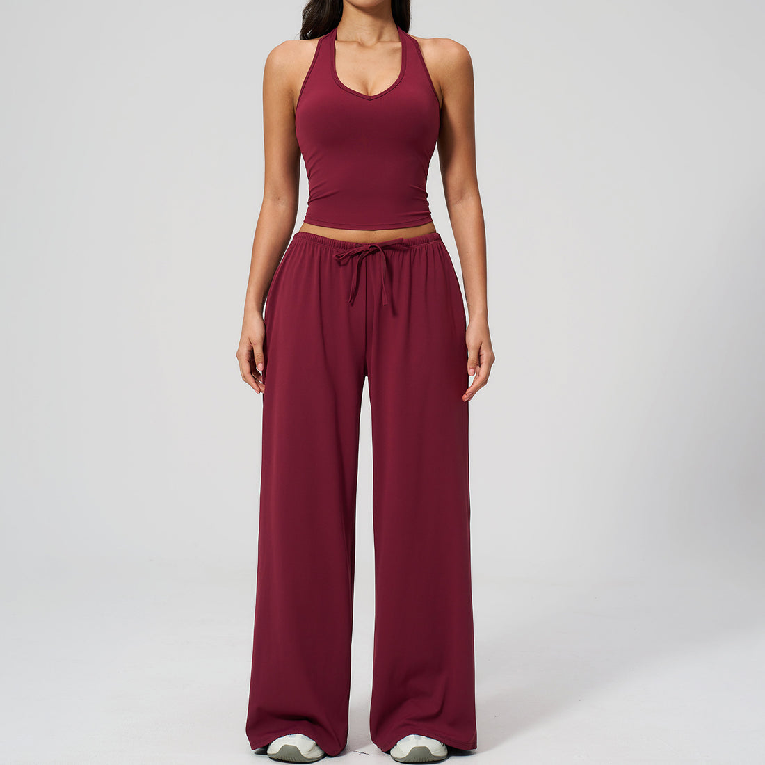 Women's burgundy halter crop top and matching wide leg trousers, front view.