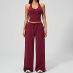 Women's burgundy halter crop top and matching wide leg trousers, front view.