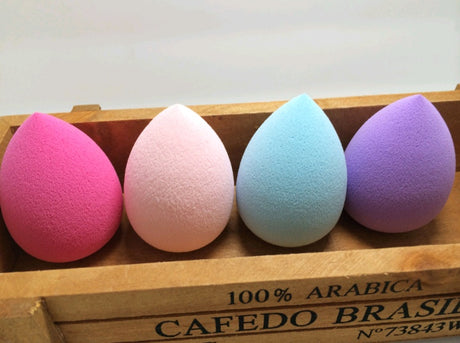 Four coloured teardrop sponges lined up in a wooden box