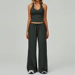 Women's dark green halter crop top and matching wide leg trousers.