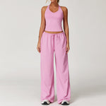 Women's pink halter crop top and matching drawstring wide leg trousers.