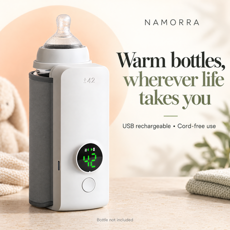 White bottle warmer with grey sleeve and round front display, shown beside a clear bottle on a pale background.