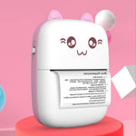 Pink mini printer on a red plinth, printing a text sheet