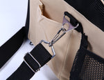 Close-up of beige carrier pocket, black strap clip and side mesh panel