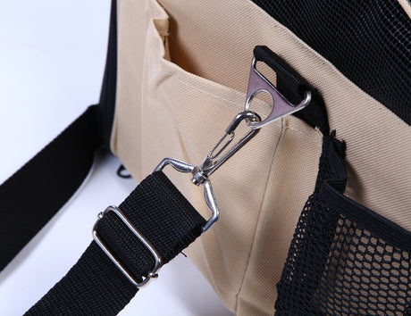 Close-up of beige carrier pocket, black strap clip and side mesh panel