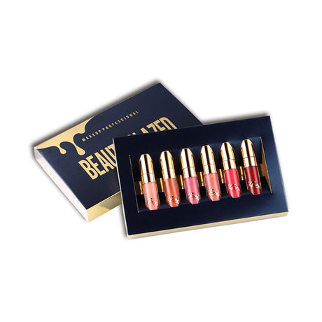 Six mini lipsticks in navy tray beside matching Beauty Glazed box