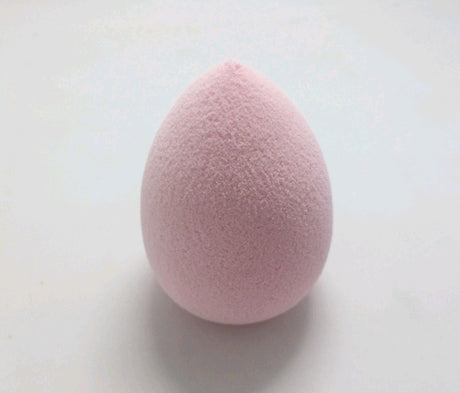 Pale pink teardrop Makeup Sponge Puff on a light surface