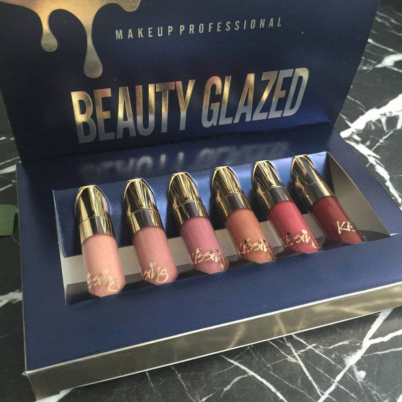 Open navy Beauty Glazed box showing six lipsticks from nude to red shades
