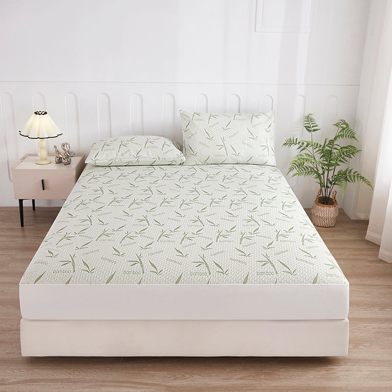 Waterproof bamboo mattress protector with a leafy print on a bed