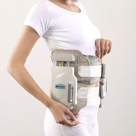 Side view of waist-worn lumbar traction device with grey straps and white adjustment unit