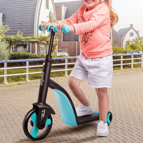 Child standing on a black and blue three-wheel scooter outdoors