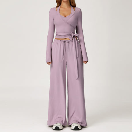 Women's lilac long sleeve wrap top worn with matching wide leg trousers.
