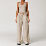 Women's beige halter crop top and matching drawstring wide leg trousers.