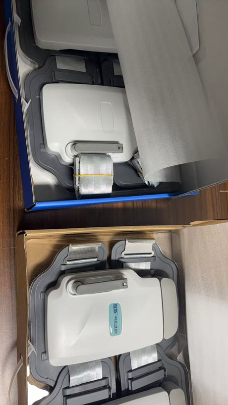 Lumbar traction devices in open boxes, showing white units, grey panels and straps