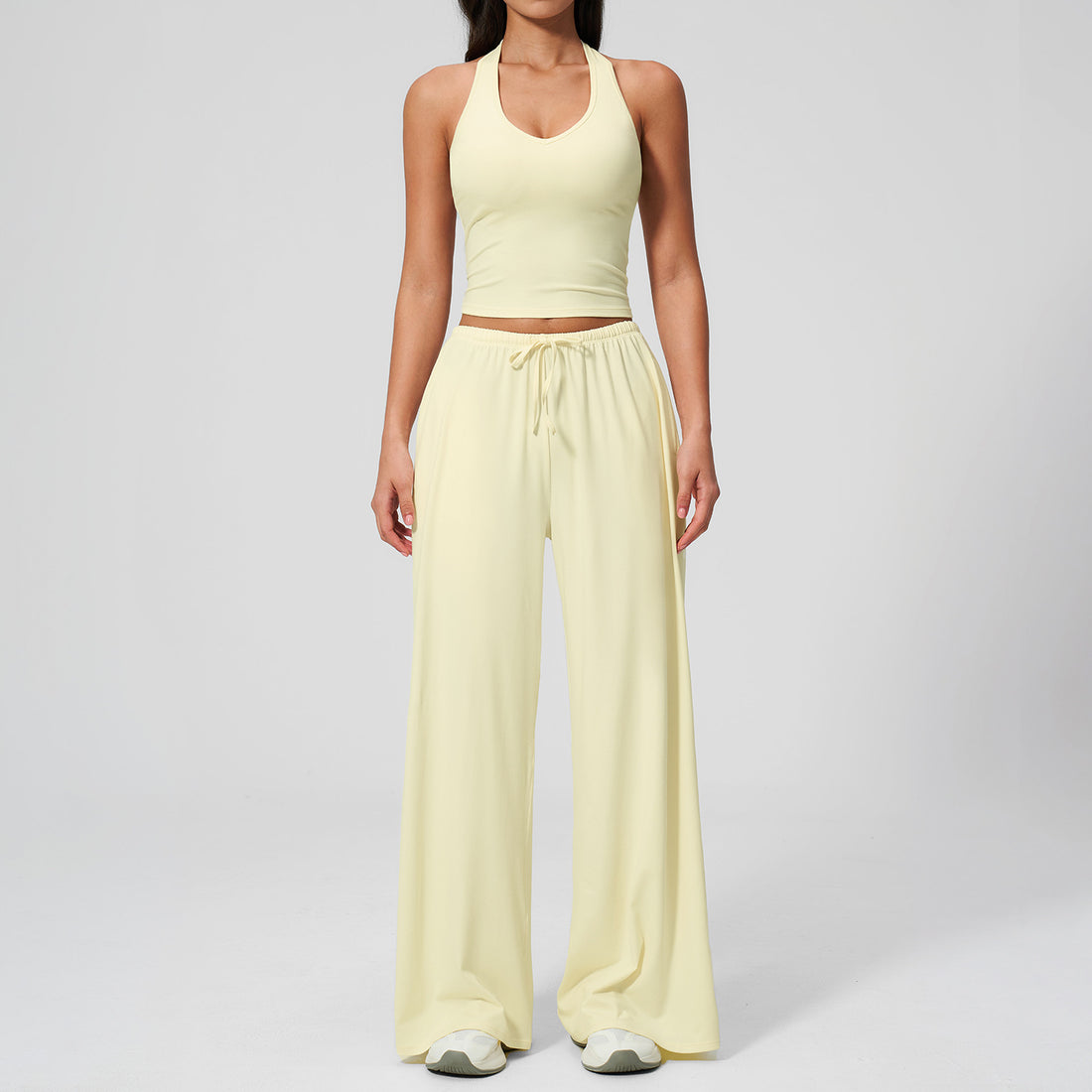 Women's pale yellow halter top and matching wide leg trousers, front view.