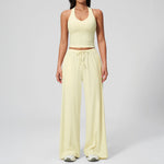 Women's pale yellow halter top and matching wide leg trousers, front view.