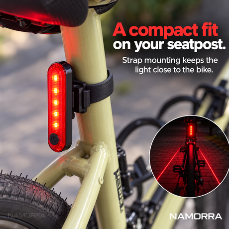 Slim red bicycle rear light attached to a seatpost with a black strap