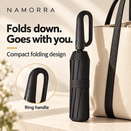 Compact folded NAMORRA umbrella with ring handle beside an everyday bag
